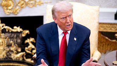 Donald Trump gestures and speaks while sitting in the Oval Office