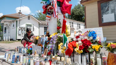 A person places flowers at a memorial for Lorenzo Salgado Araujo in Houston.