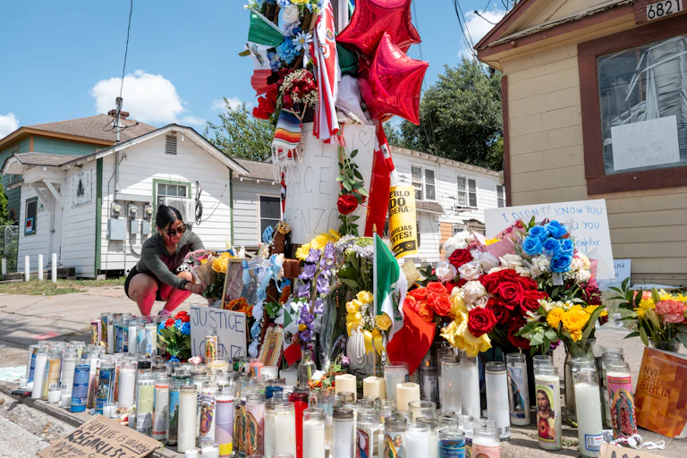 A person places flowers at a memorial for Lorenzo Salgado Araujo in Houston, Texas.