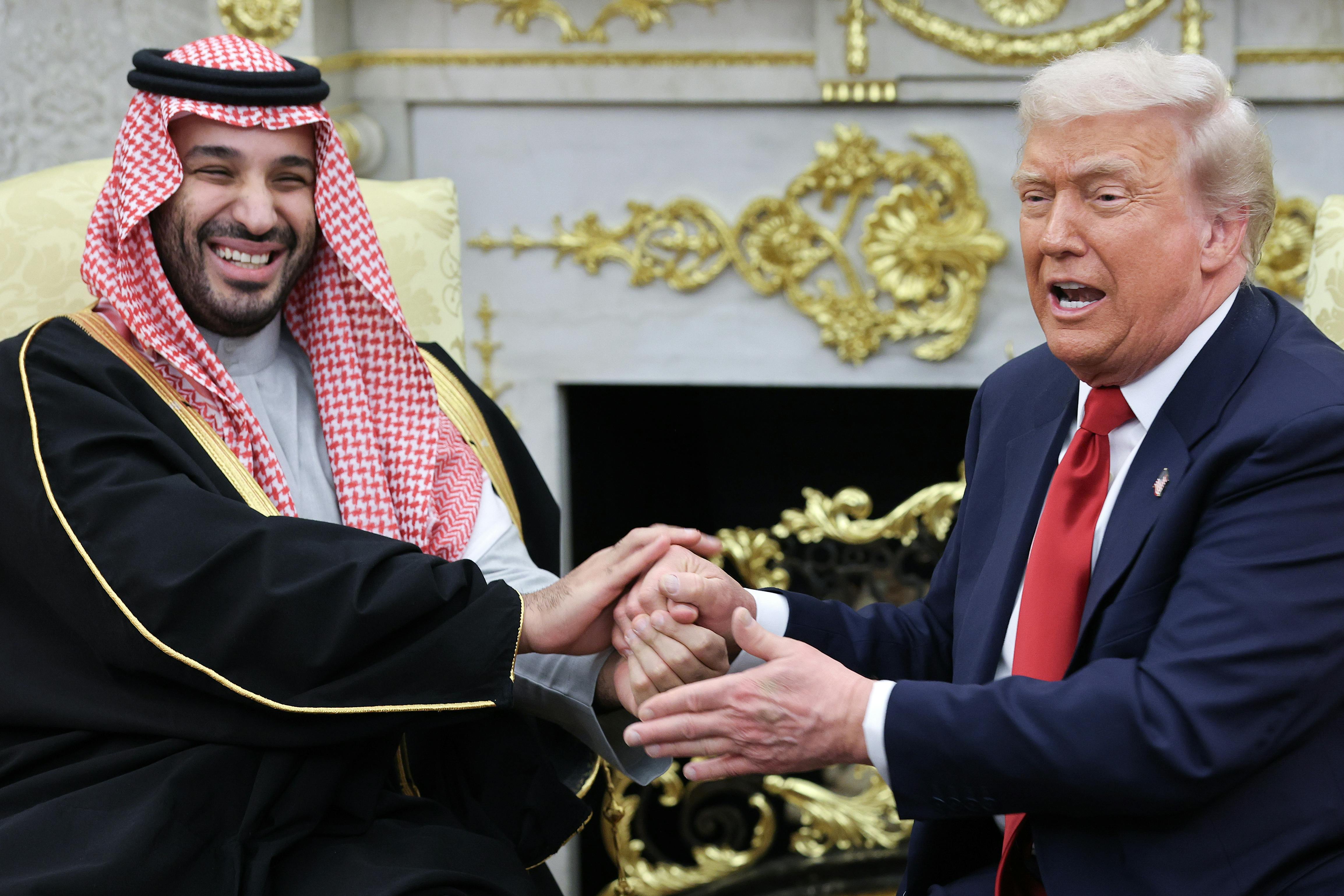 Saudi Crown Prince Mohammed bin Salman and Donald Trump hold each other’s hands (strangely) in the Oval Office of the White House.