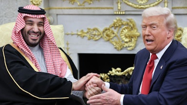 Saudi Crown Prince Mohammed bin Salman and Donald Trump hold each other’s hands (strangely) in the Oval Office of the White House.