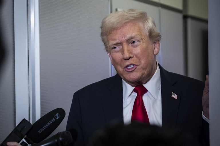 Donald Trump speaks to reporters aboard Air Force One.