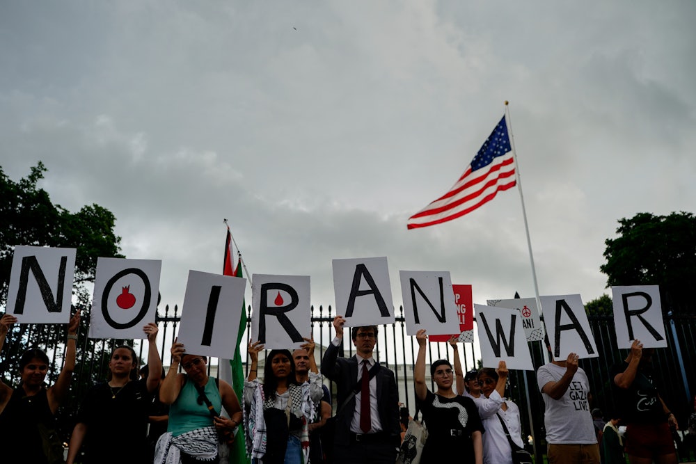 Demonstrators hold signs during a protest against war with Iran outside the White House on Wednesday, June 18, 2025.