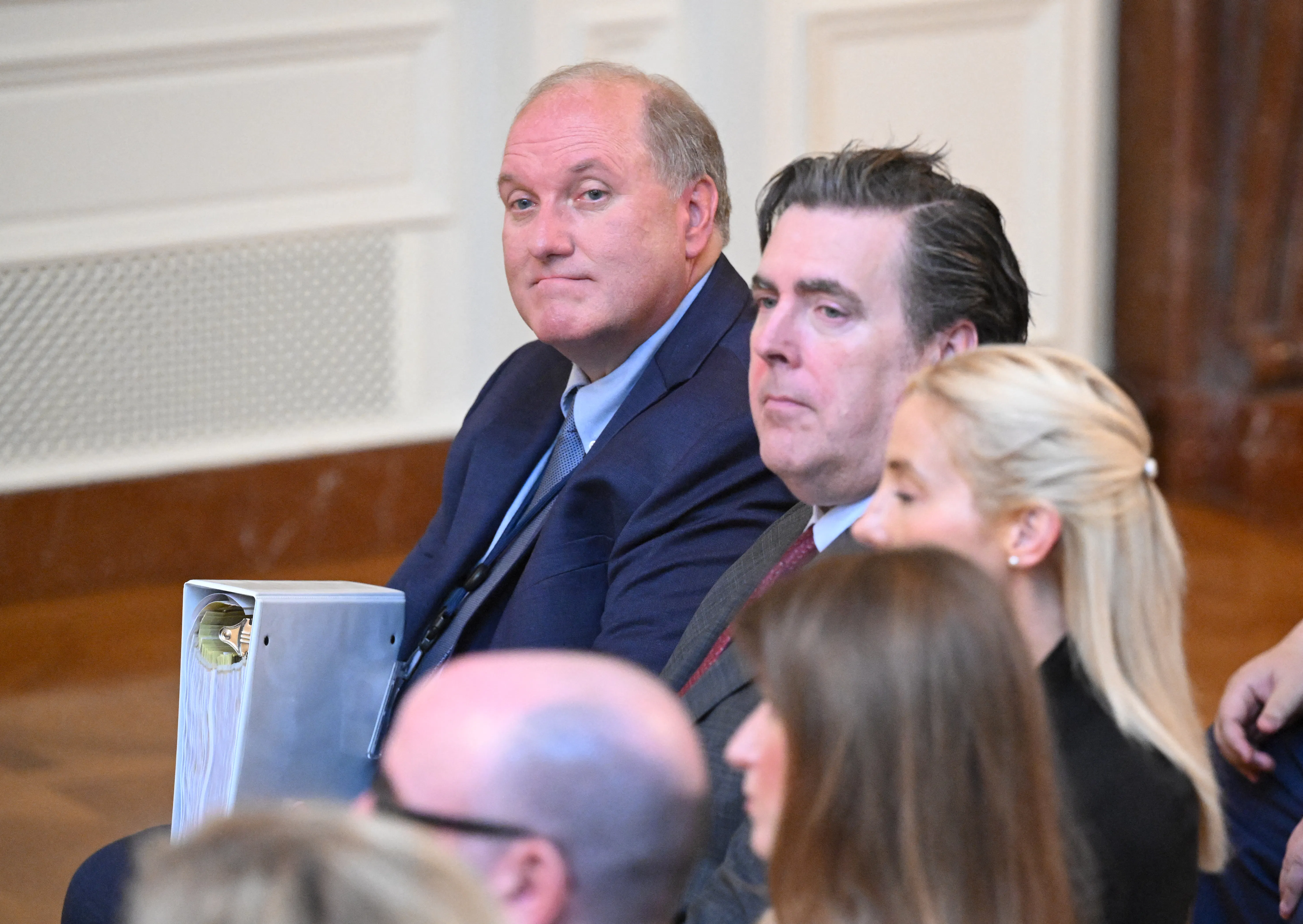 John Solomon holds a biner and appears to zone out while seated.