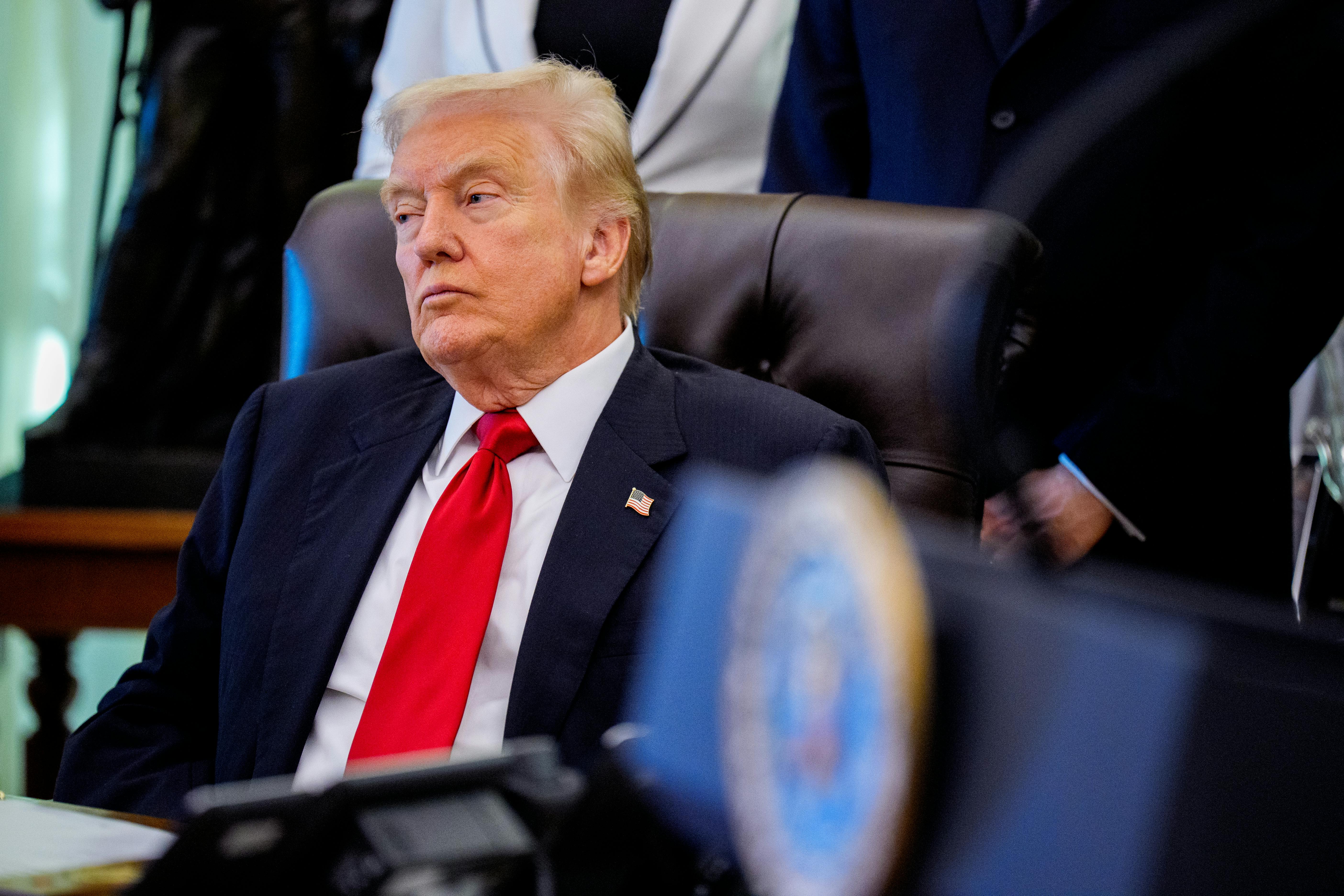 Trump leans back in chair, looking tired