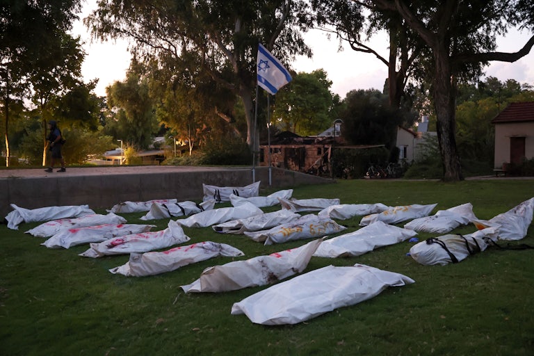 Covered bodies are gathered at Kibbutz Be'eri