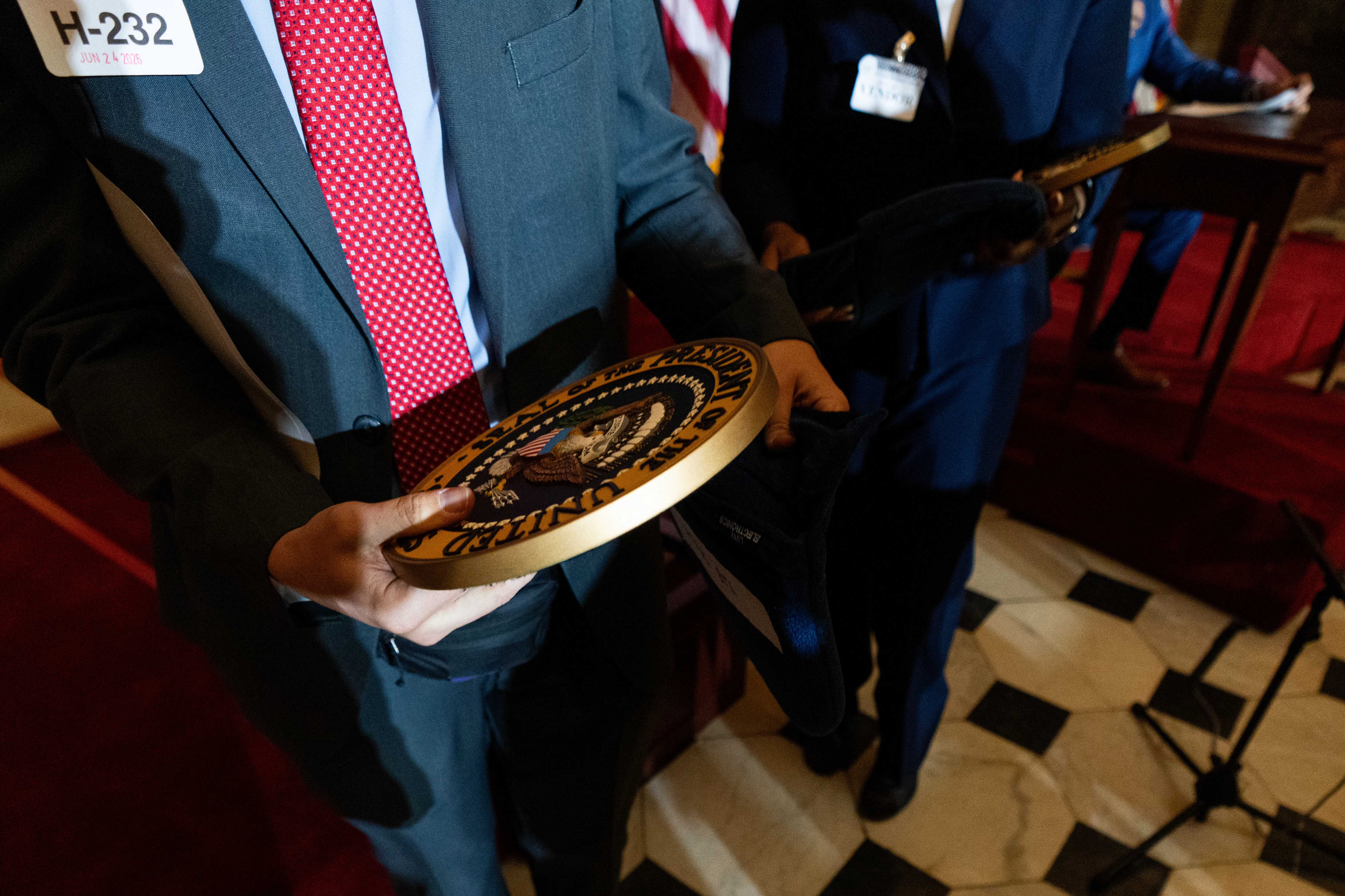 Someone holds the presidential seal in their hands