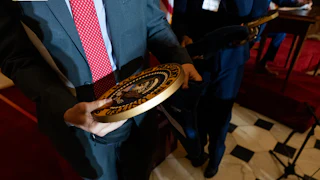 Someone holds the presidential seal in their hands