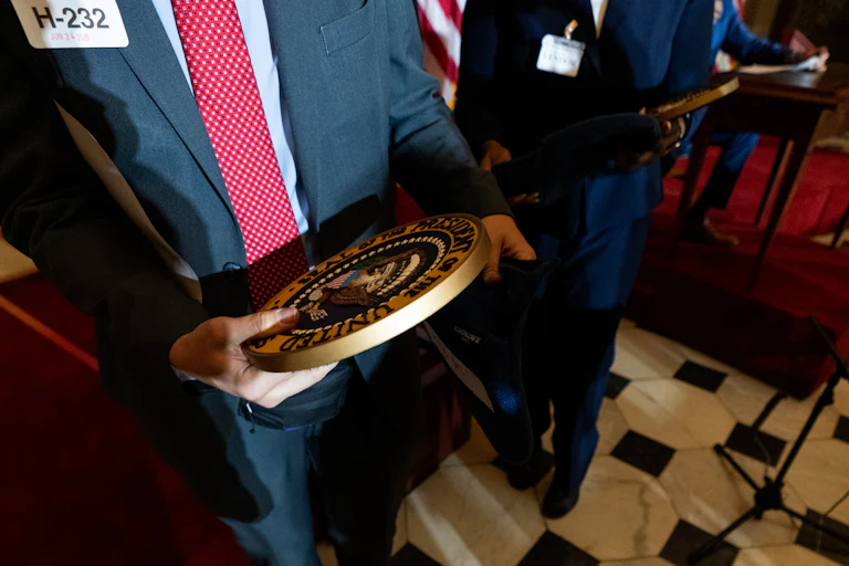 Someone holds the presidential seal in their hands
