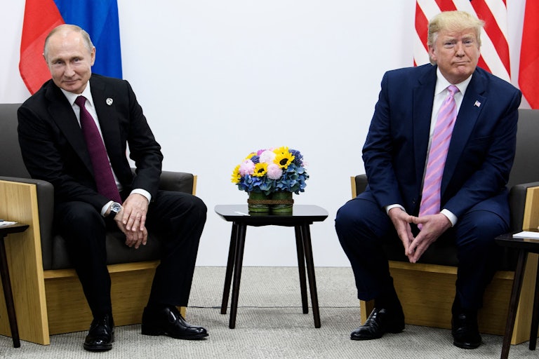 Vladimir Putin and Donald Trump smile and sit next to each other
