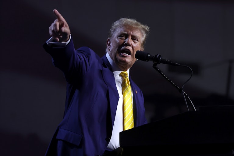 Donald Trump speaks at a lecturn and points with his finger off camera