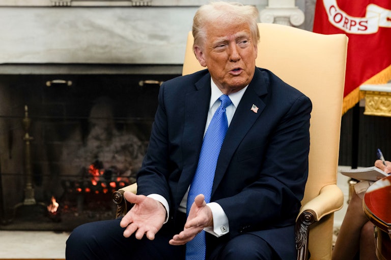 Donald Trump speaks and gestures while sitting in the Oval Office during a press conference with the Japanese prime minister