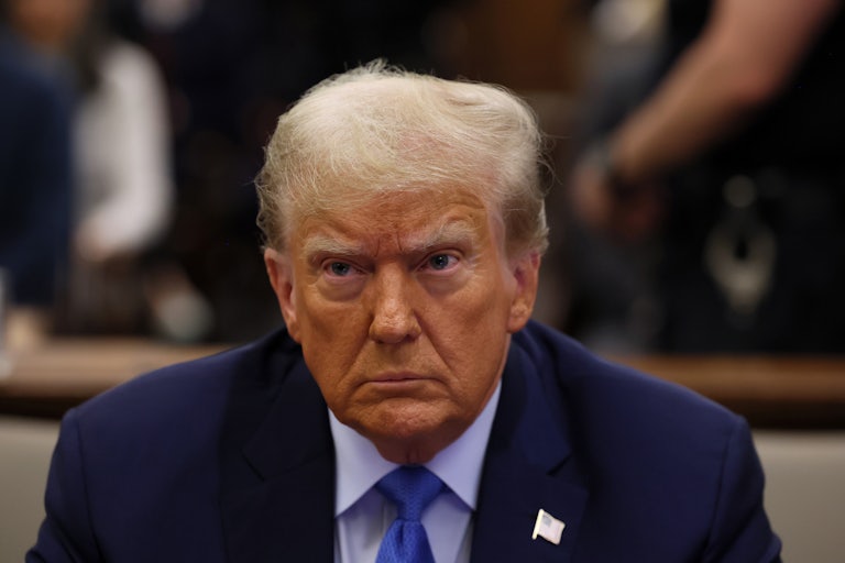 Donald Trump wears a navy suit and looks off camera. (It appears as if he is sitting.)