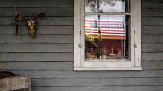 A window with a U.S. flag in the reflection