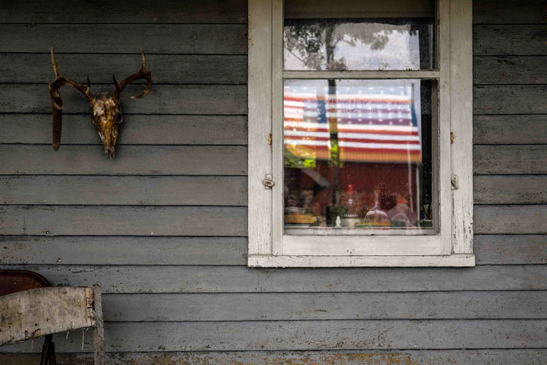 A window with a U.S. flag in the reflection