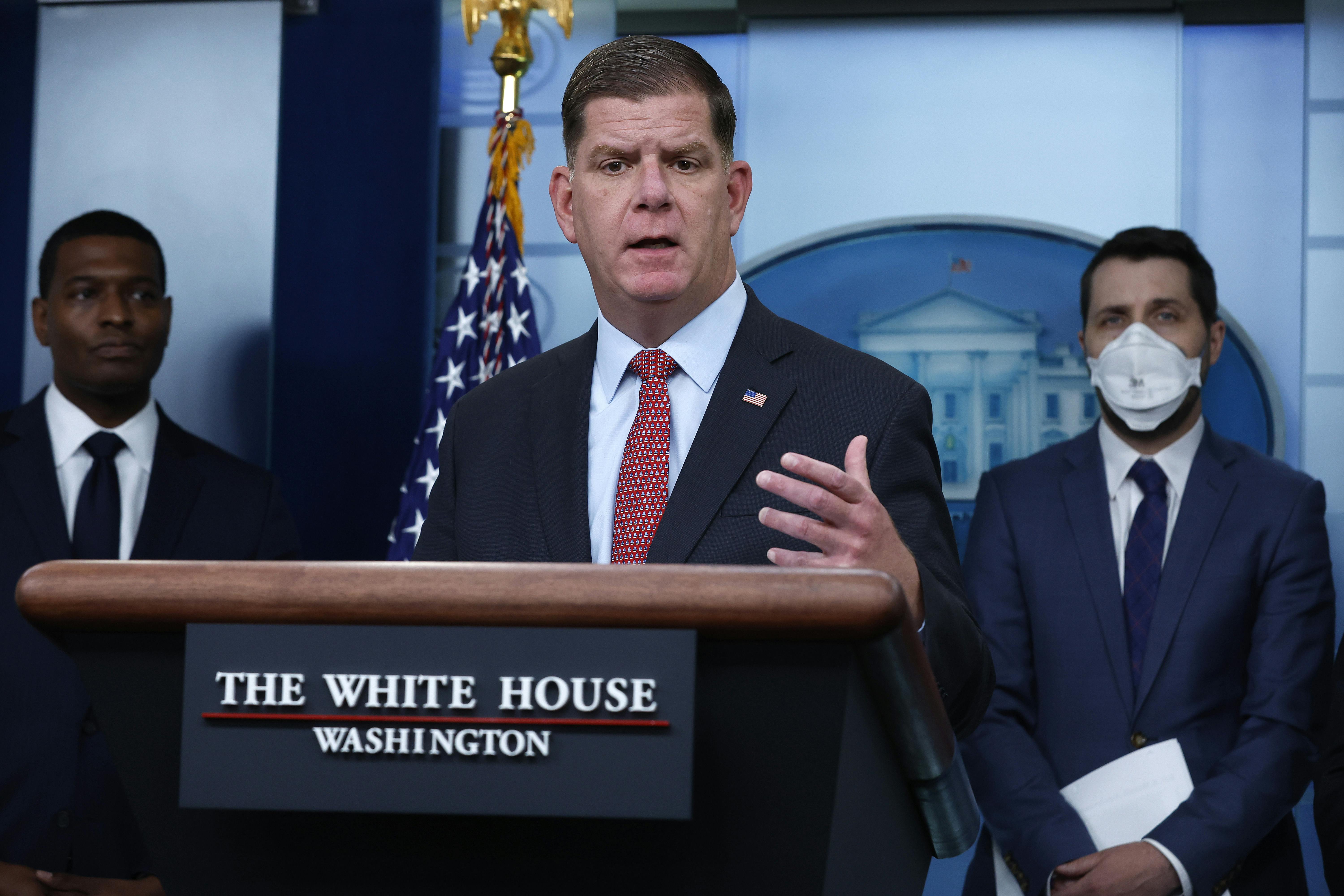 U.S. Labor Secretary Marty Walsh stands behind a lectern at the White House