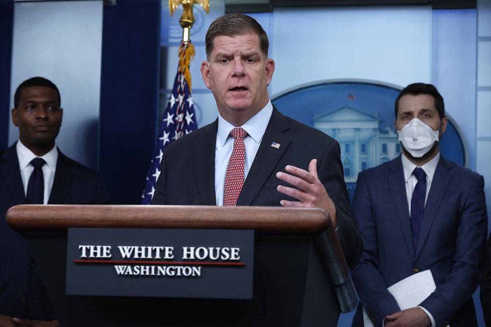 U.S. Labor Secretary Marty Walsh stands behind a lectern at the White House