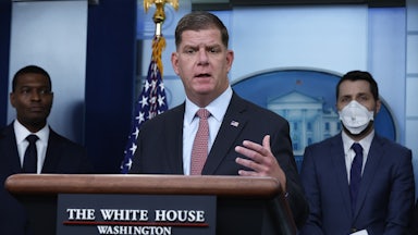 U.S. Labor Secretary Marty Walsh stands behind a lectern at the White House