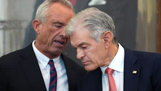 Robert F. Kennedy Jr. says something to Dr. Oz as he bends down to hear