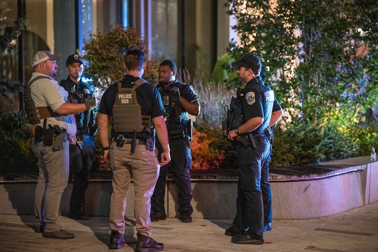 Federal officers stand on a street corner in Washington, D.C.