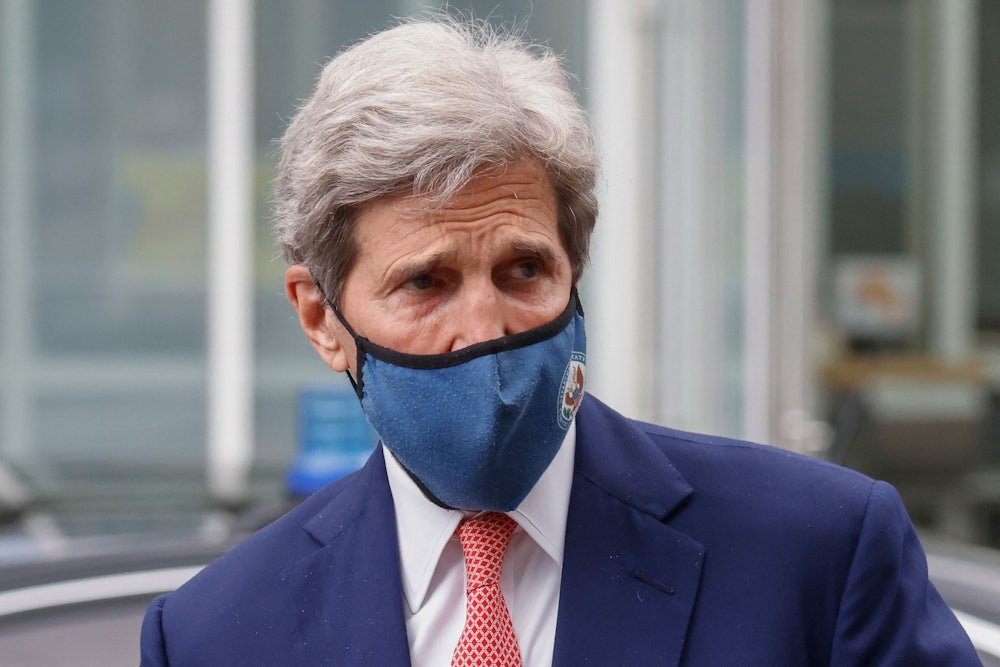 Climate envoy John Kerry, wearing a face mask, looks to the side.
