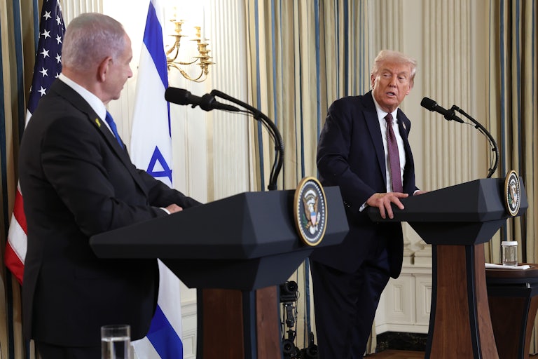Israeli Prime Minister Benjamin Netanyahu and Donald Trump look at each other and speak while standing at podiums during a press conference
