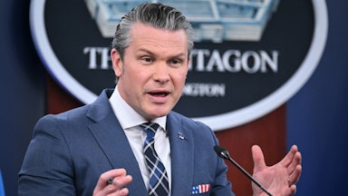 Defense Secretary Pete Hegseth gestures while speaking at a podium