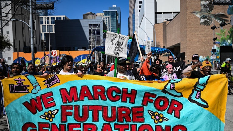Protesters hold a banner reading "We March for Future Generations."