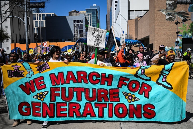 Protesters hold a banner reading "We March for Future Generations."