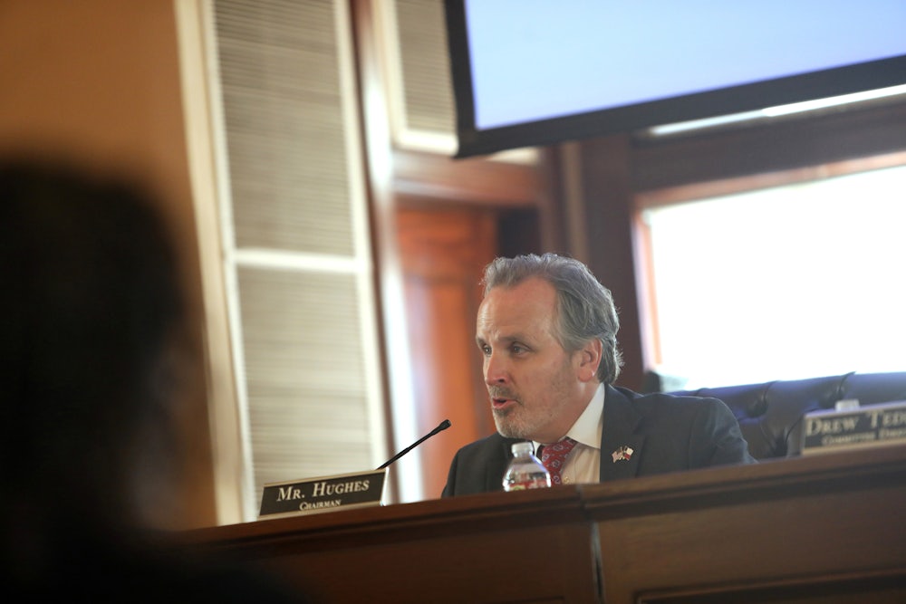 Bryan Hughes sits at a desk and speaks into a microphone.