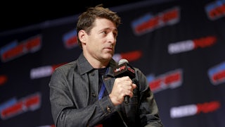 News anchor Tony Dokoupil speaks into a microphone while sitting in a chair