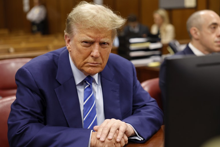 Donald Trump looks at the camera while sitting in a courtroom