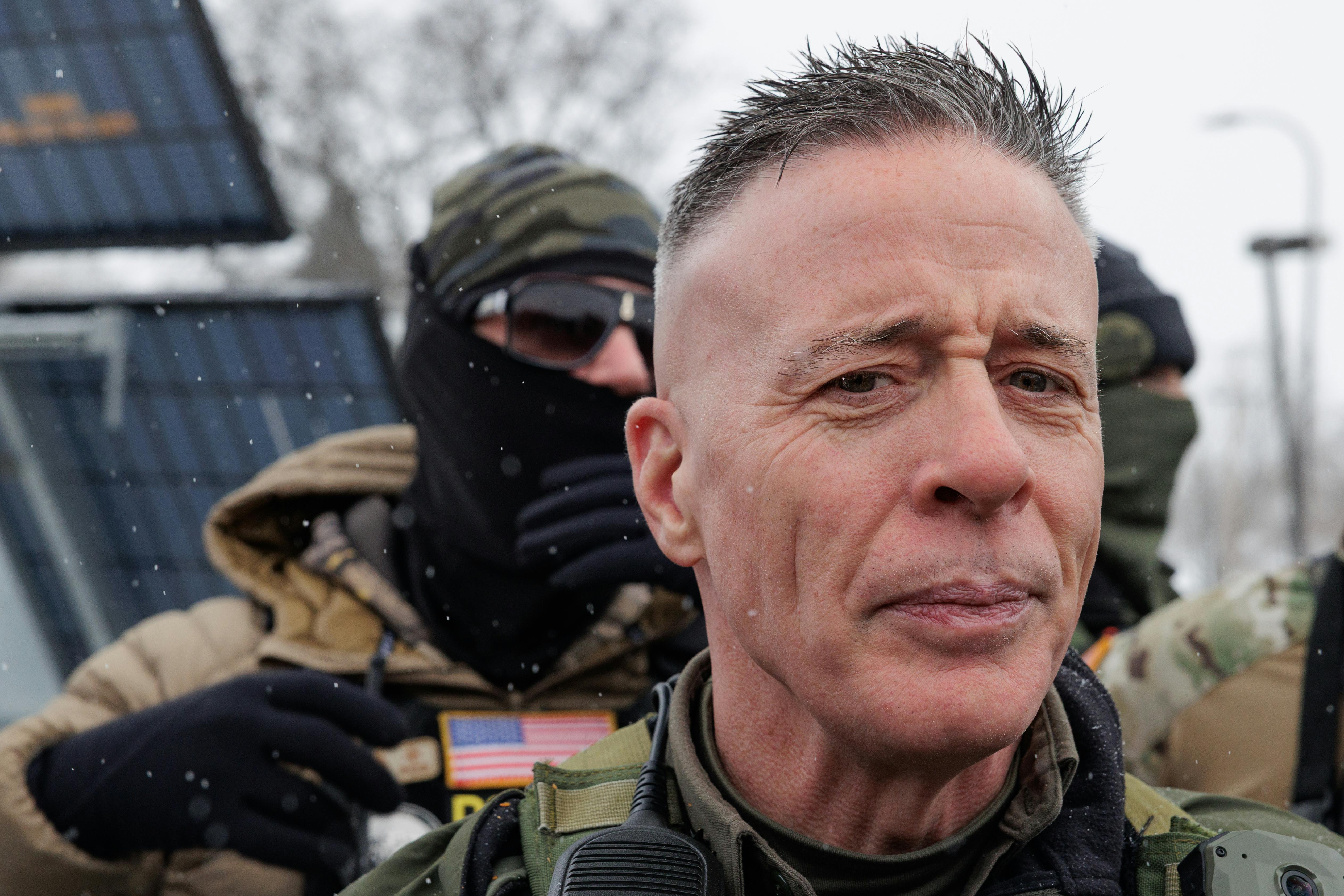 CBP Commander Gregory Bovino stands with masked federal immigration agents outside a gas station in Minneapolis, Minnesota