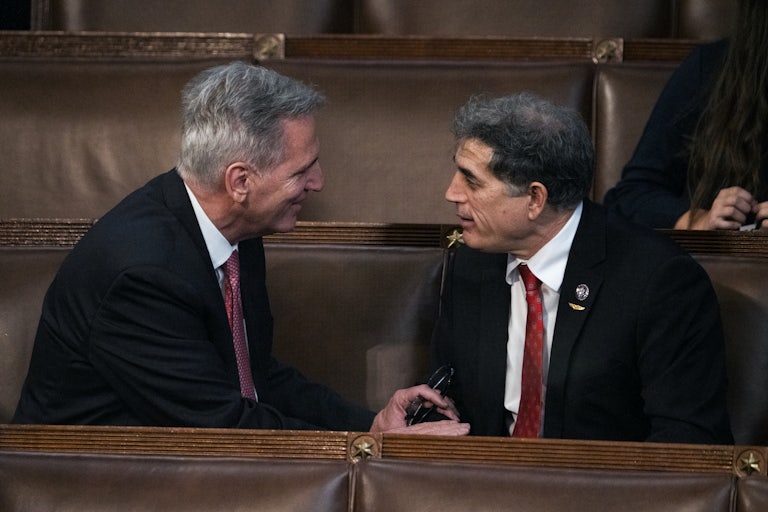 Andrew Clyde and Kevin McCarthy talk while seated.