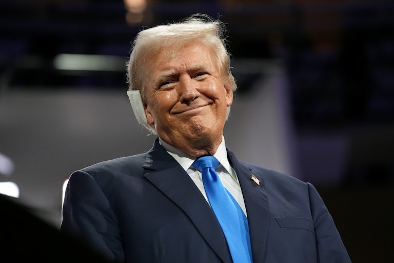 Donald Trump smiles with a giant cushion on his right ear