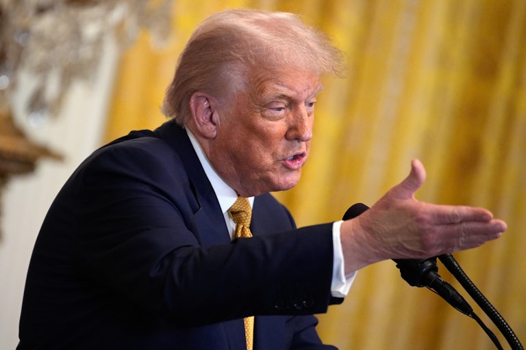 Donald Trump gestures while speaking at a podium during a White House event