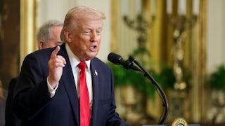 Donald Trump points while speaking at a podium in the White House.