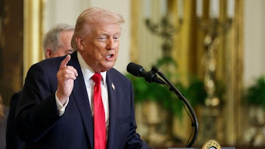 Donald Trump points while speaking at a podium in the White House.