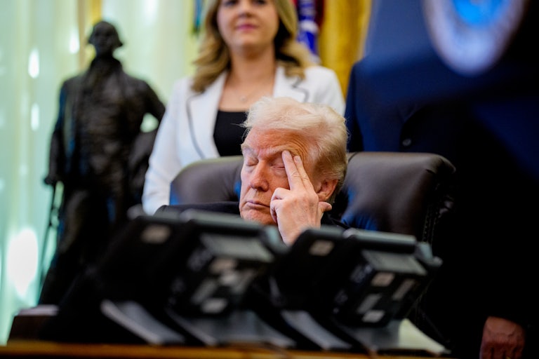 Donald Trump puts two fingers to his brow as he falls asleep at his desk in the Oval Office of the White House.