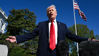 Donald Trump holds his arms out to the side and speaks while standing outside the White House