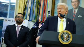FBI Director Kash Patel stands next to Donald Trump, who speaks at a podium in the Oval Office