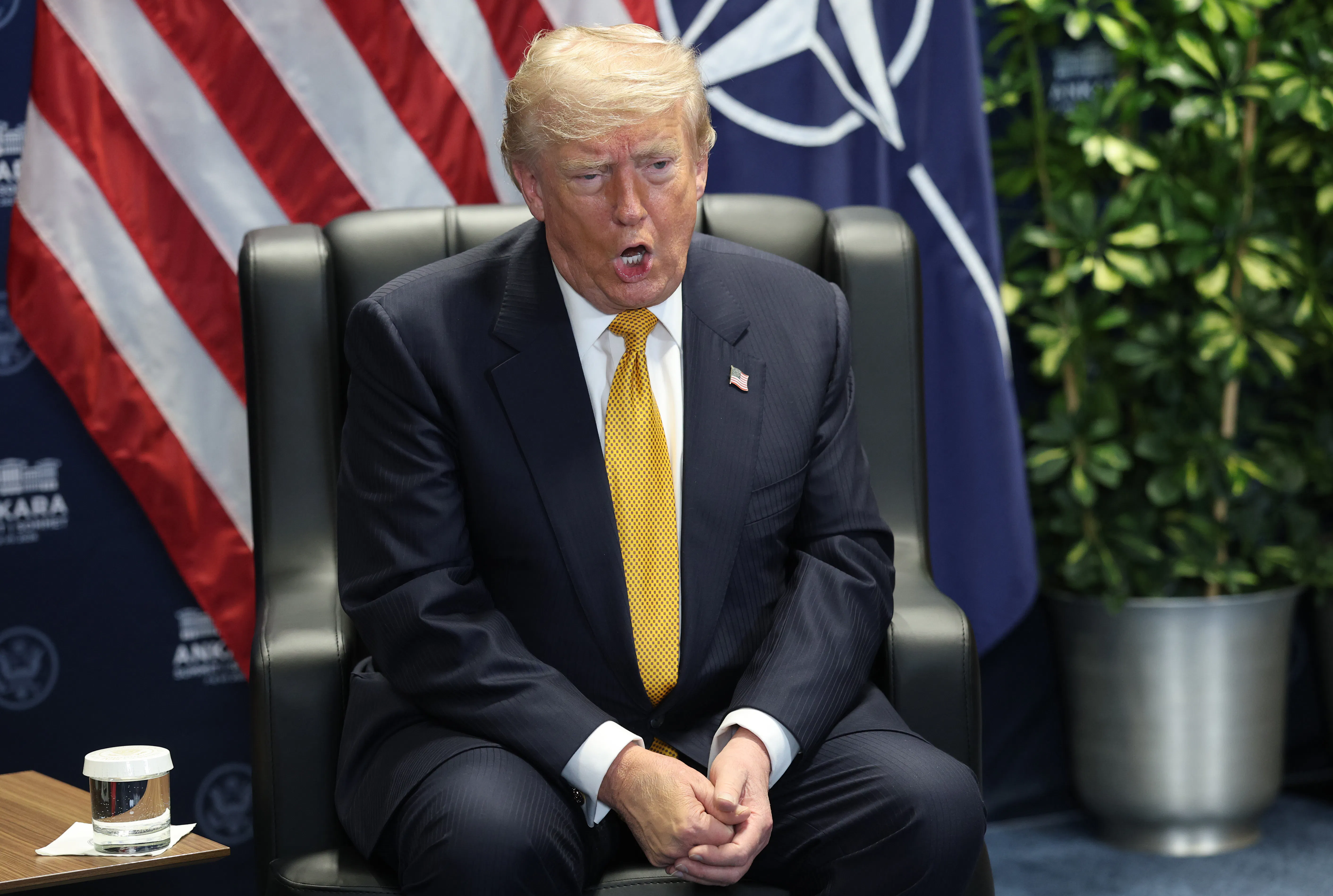 Donald Trump speaks while sitting in a chair