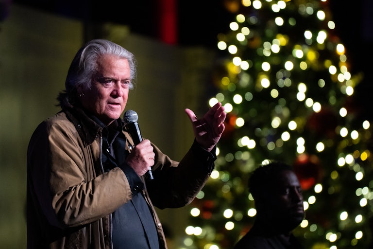 Steve Bannon gestures while speaking into a microphone