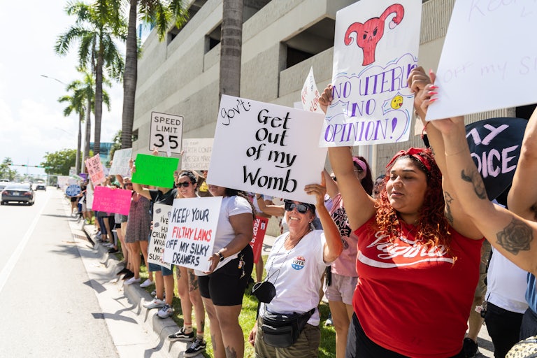 People hold up pro-abortion rights protest signs