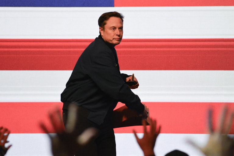 Elon Musk throws something to a crowd in Wisconsin.