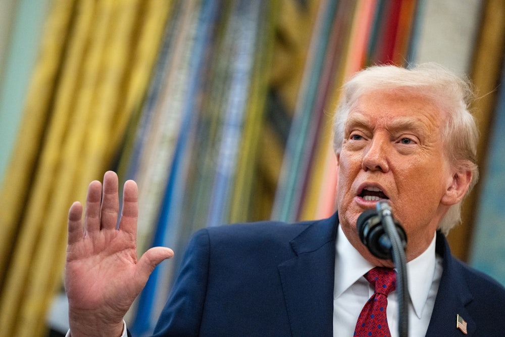 Trump holds up a hand while speaking.