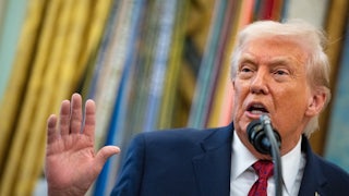 Trump holds up a hand while speaking.