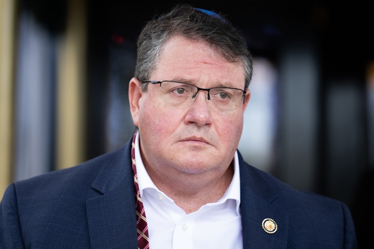 Representative Randy Fine stands with his necktie undone