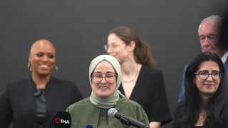Tufts University grad student Rumeysa Ozturk speaks into microphones at a podium