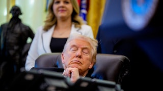 Donald Trump sits at his desk in the Oval Office with his eyes closed